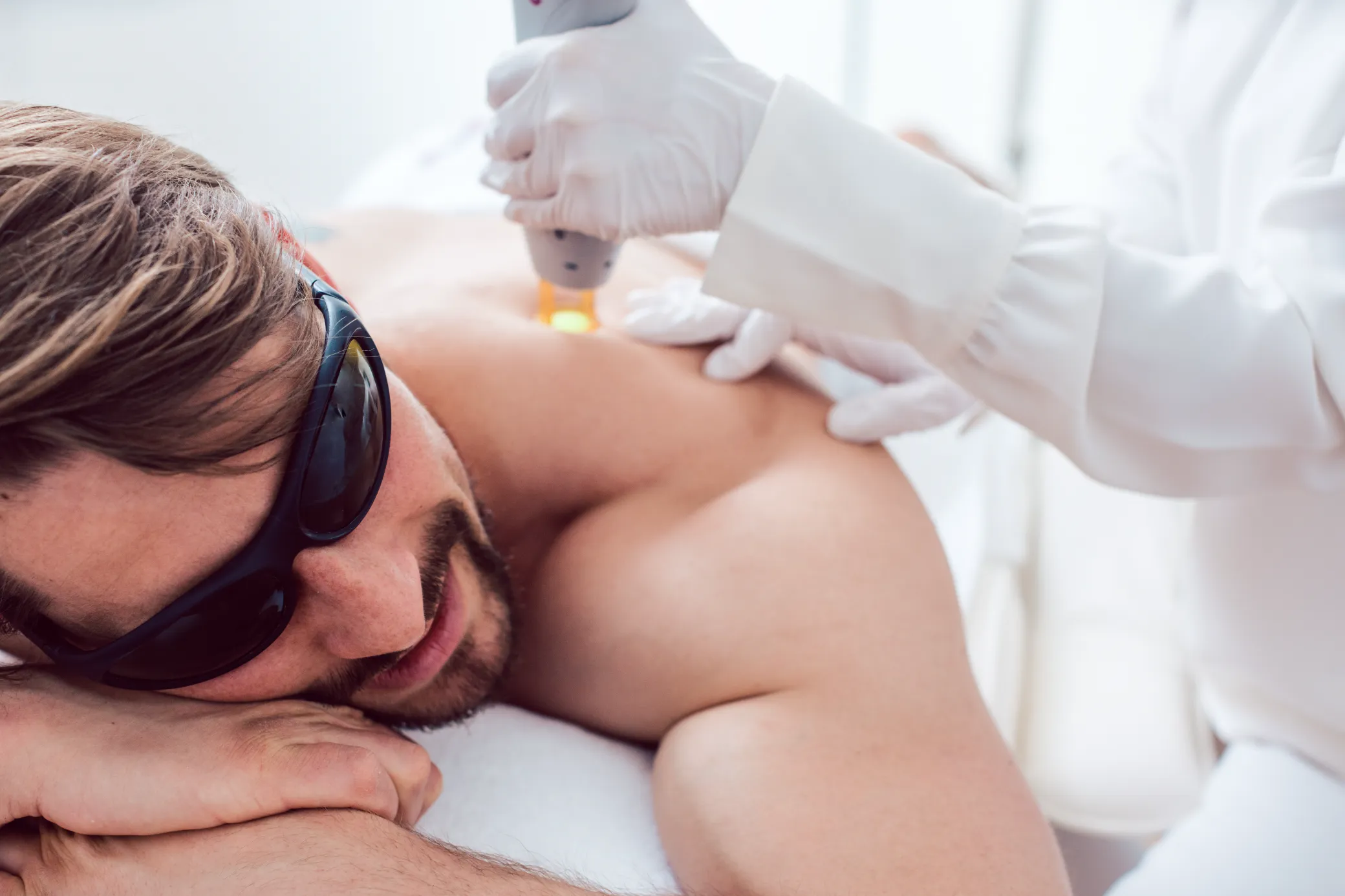 Man receiving a safe, personalized laser treatment at a Colorado Springs medical aesthetics clinic.
