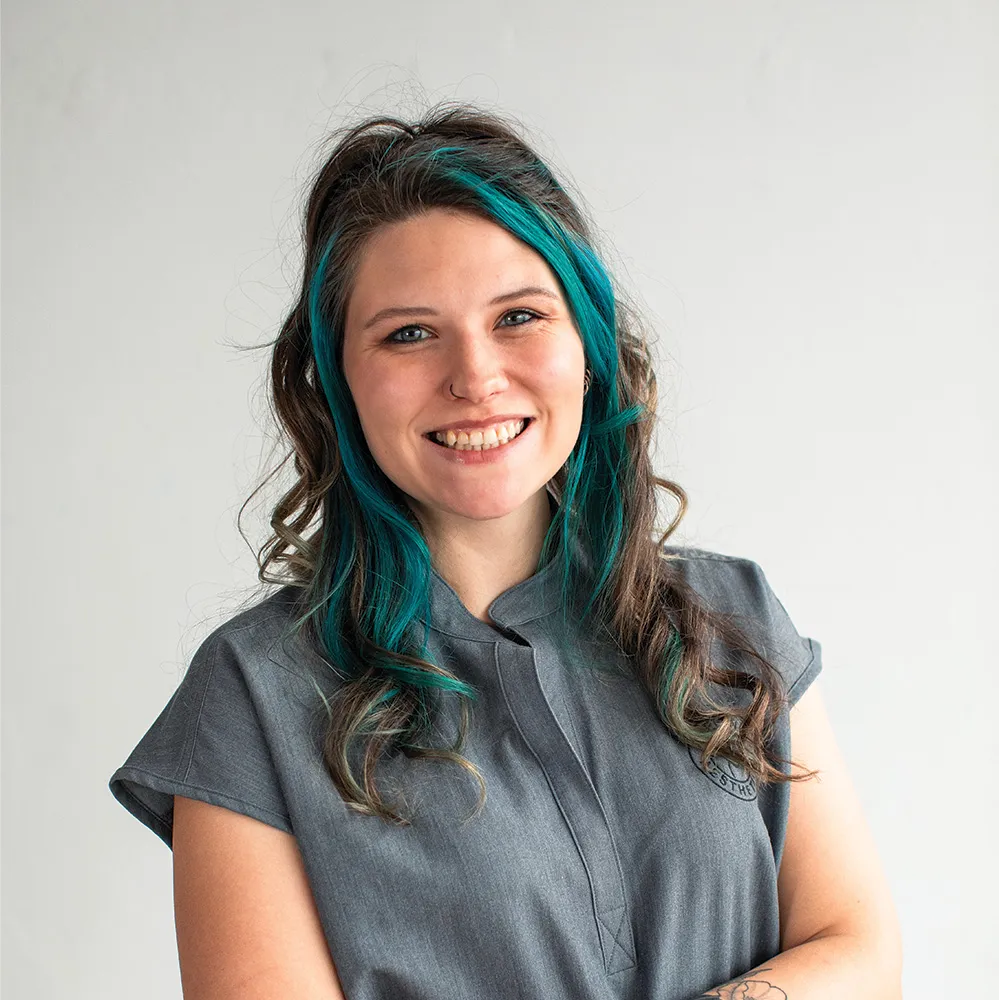 Smiling staff member at Refine Aesthetics medical clinic in Colorado Springs.